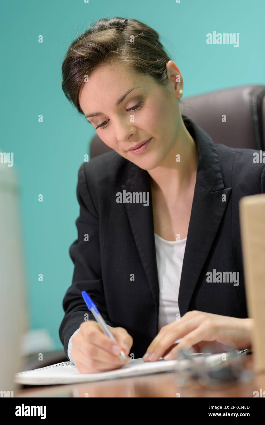 belle femme exécutive écrivant dans son bureau Banque D'Images