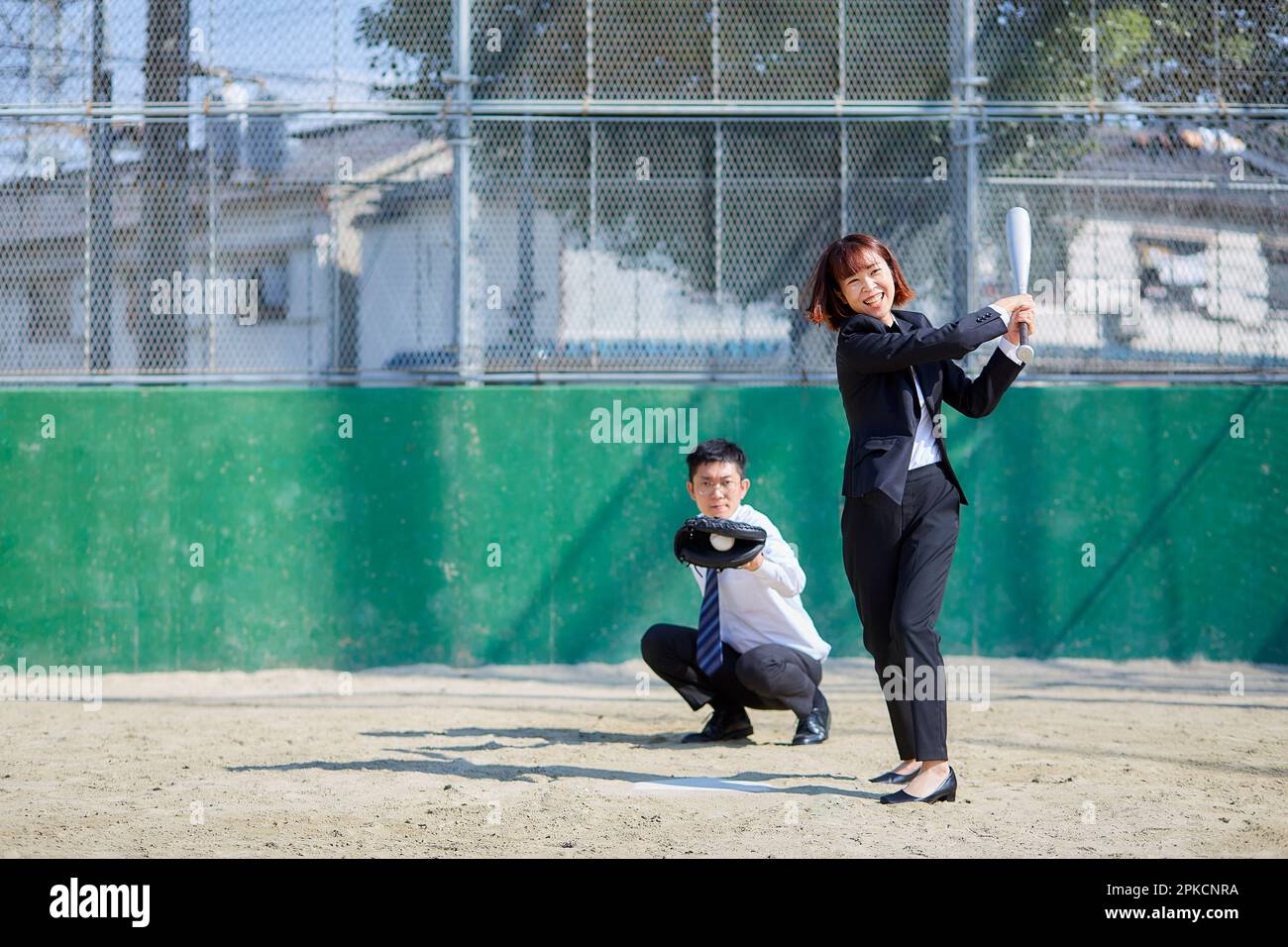 Homme et femme jouant au baseball en costume Banque D'Images