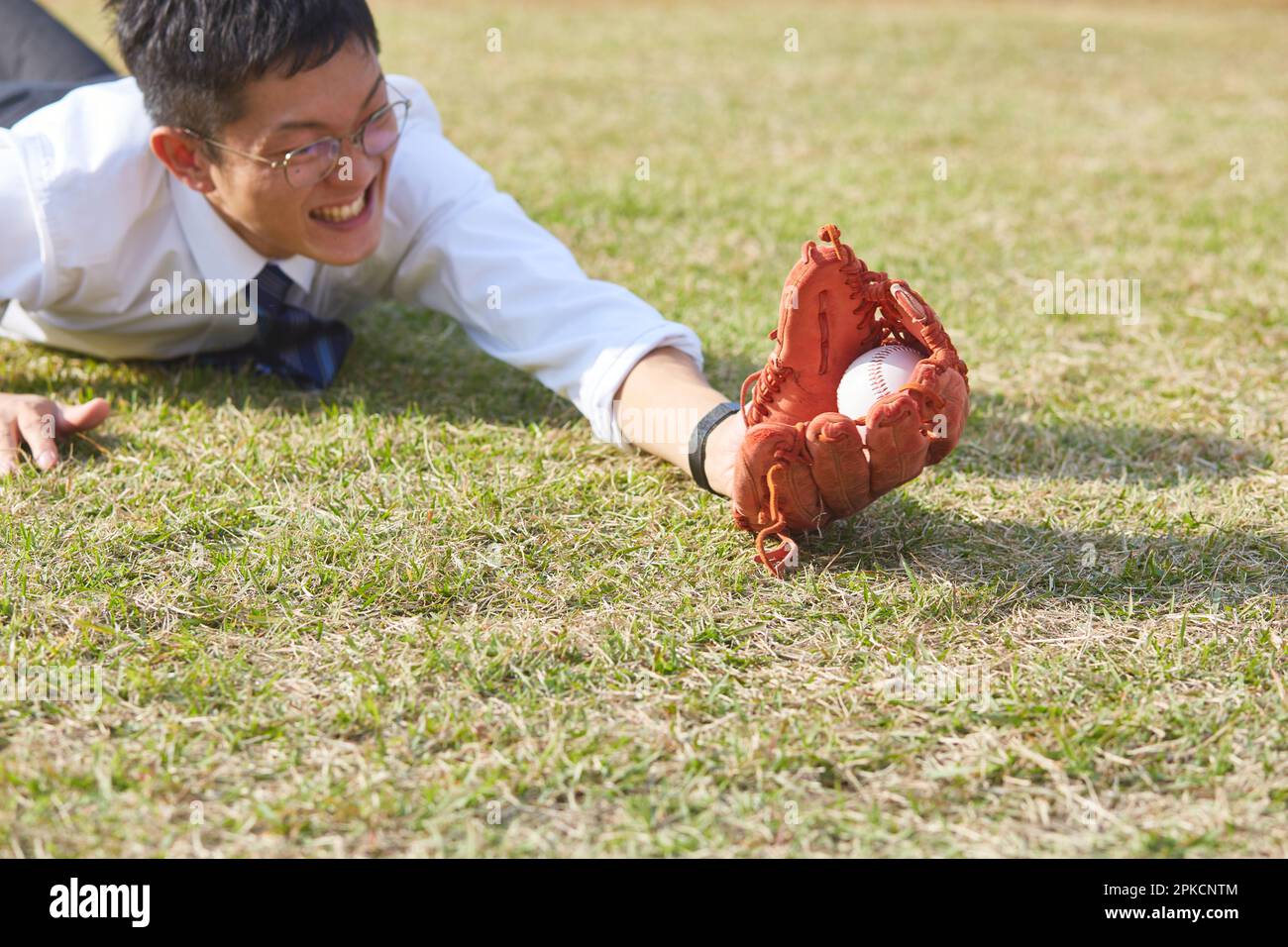 Homme en costume de plongée pour attraper le baseball Banque D'Images