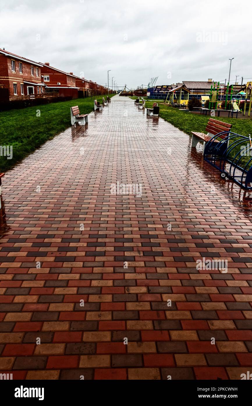 Trottoir de marche dans un village vide pendant la pluie. Banque D'Images