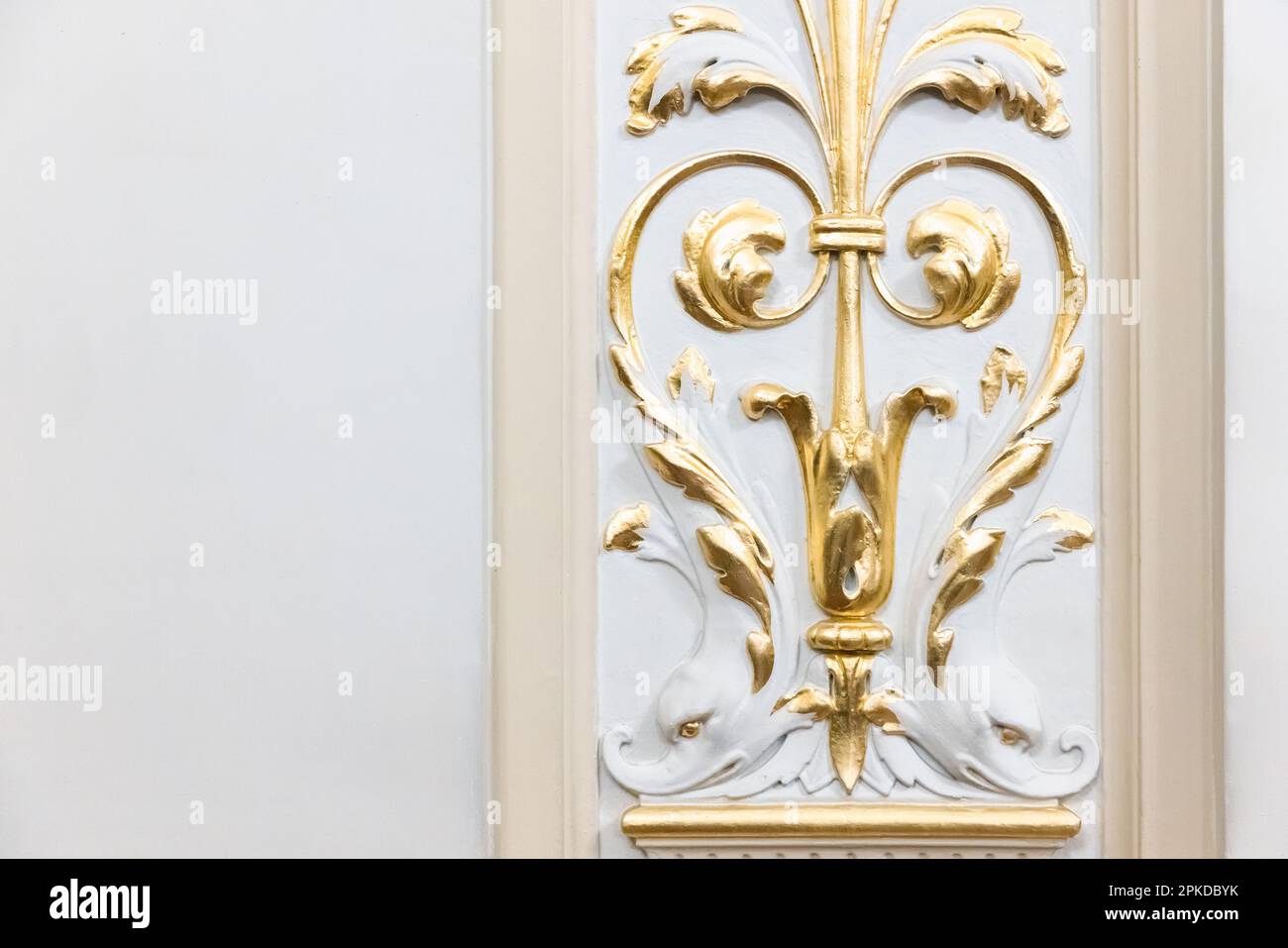 Intérieur de luxe classique, éléments dorés de décoration en gypse sur un mur blanc Banque D'Images