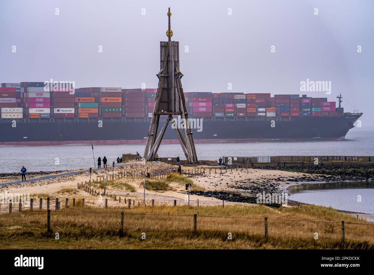 Épais brouillard en hiver, suspendu sur l'embouchure de l'Elbe dans la mer du Nord, la marque de mer et le point de repère Kugelbake bateau à conteneurs NYK venus, entre dans le Bas E Banque D'Images