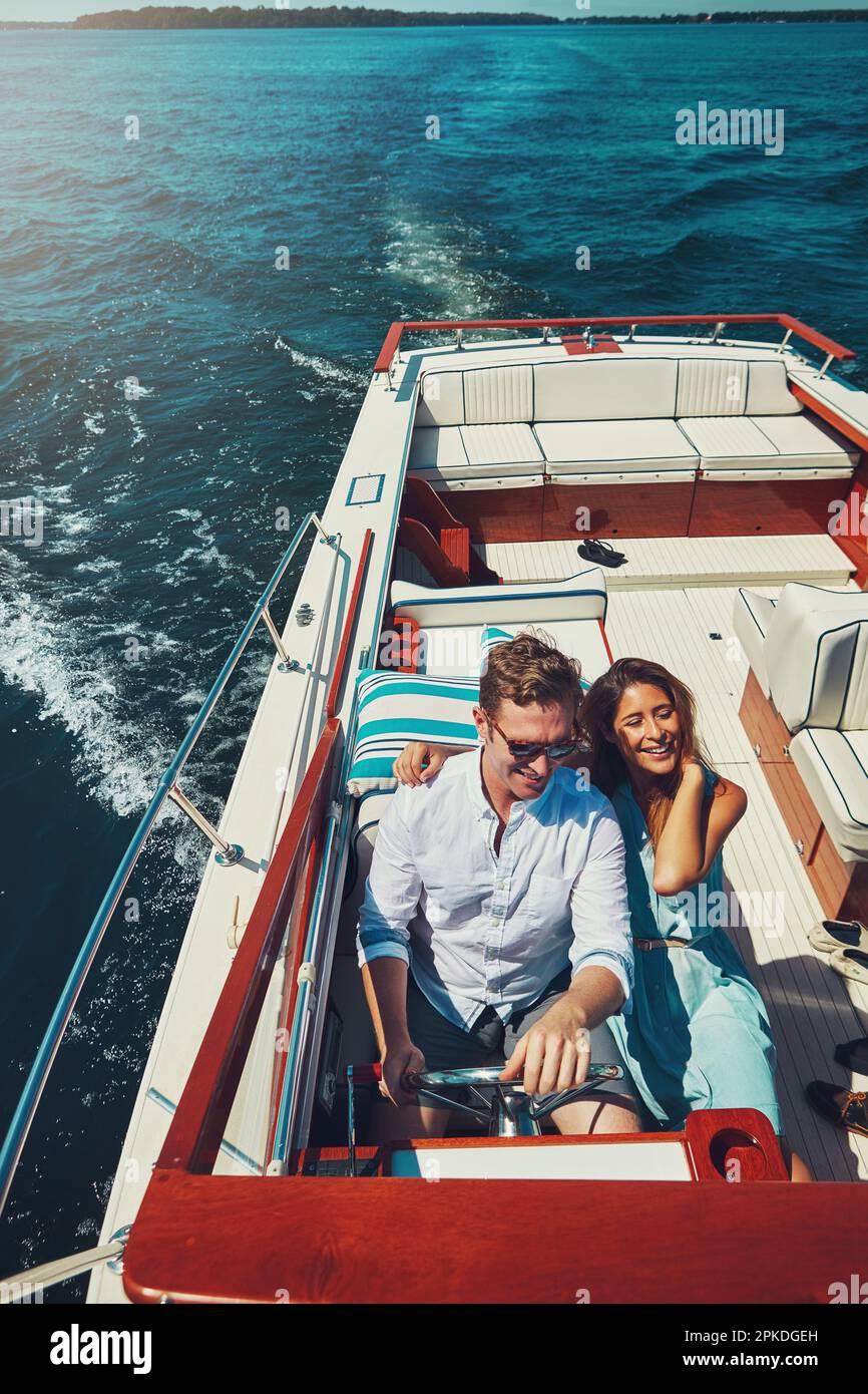 Le plus heureux en haute mer. Photo en grand angle d'un jeune couple affectueux qui navigue en haute mer dans son yacht. Banque D'Images