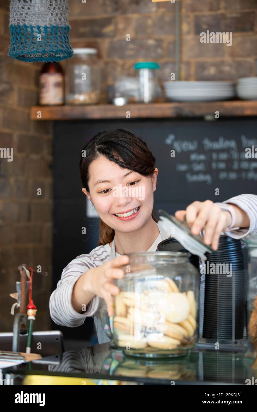 Serveuse souriante travaillant dans un café Banque D'Images