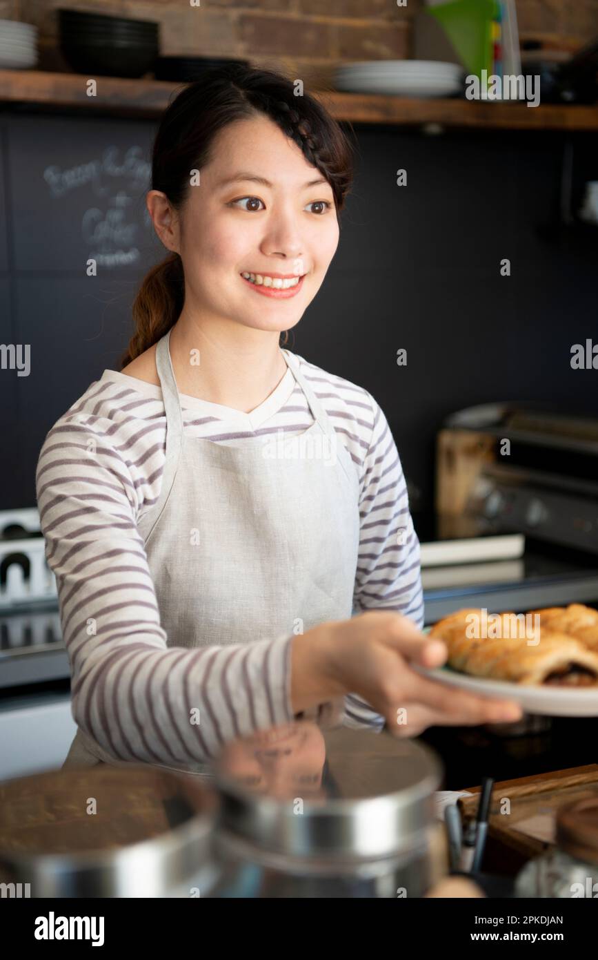 Une serveuse souriante travaillant dans un café Banque D'Images