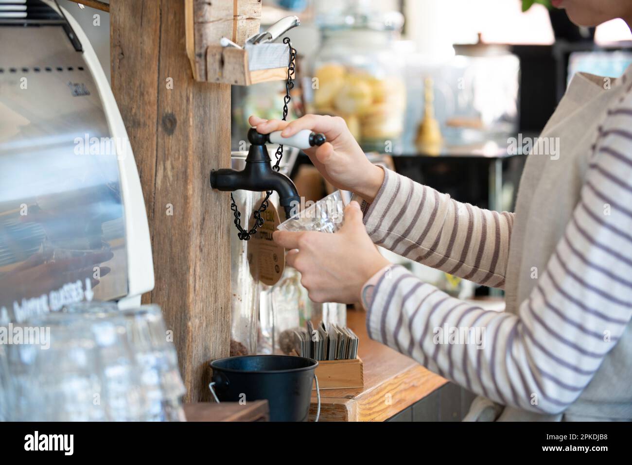 Une serveuse souriante au travail dans un café Banque D'Images
