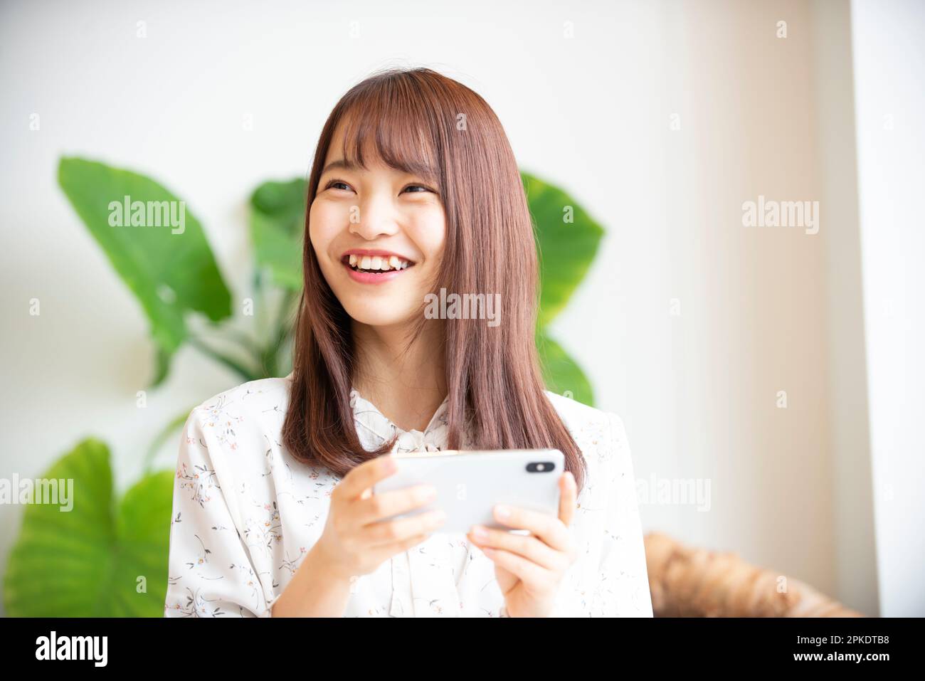 Jeune femme tenant un téléphone intelligent Banque D'Images