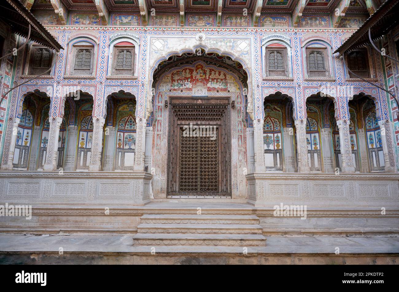 Tableaux colorés et porte en bois sculpté du musée Kamal Morarka Haveli à Shekhawati. Les marchands Marwari ont construit le grand havelis dans le Shekhawati Banque D'Images
