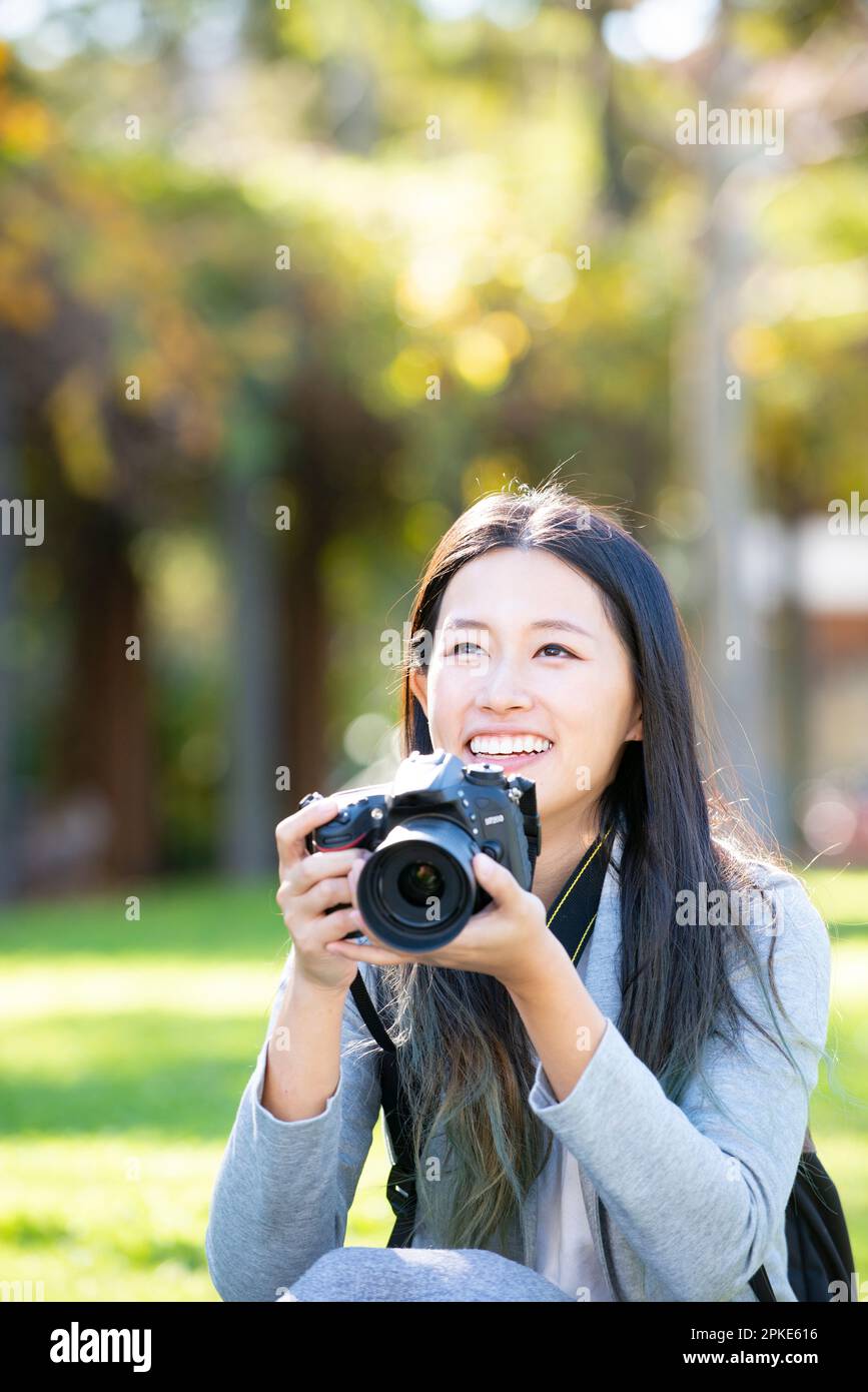 Une femme riant avec un appareil photo reflex Banque D'Images