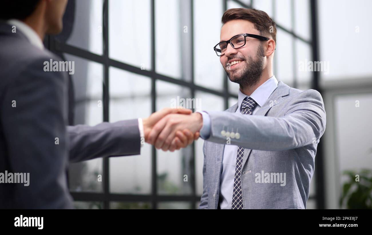 Des hommes d'affaires heureux se saluent au bureau. Banque D'Images