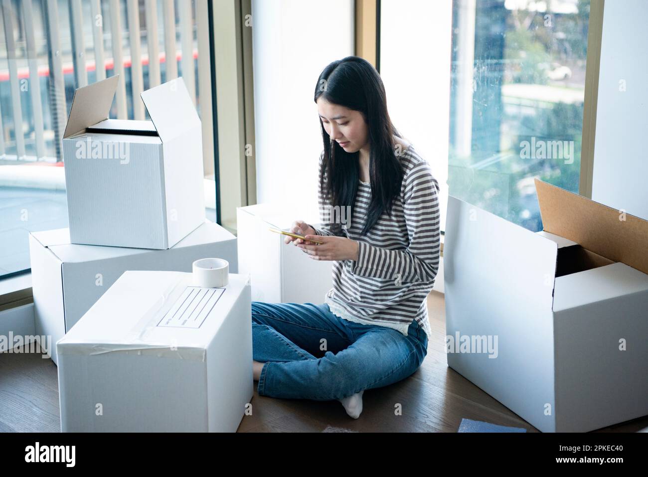 Femme touchant son téléphone entouré de carton mobile Banque D'Images