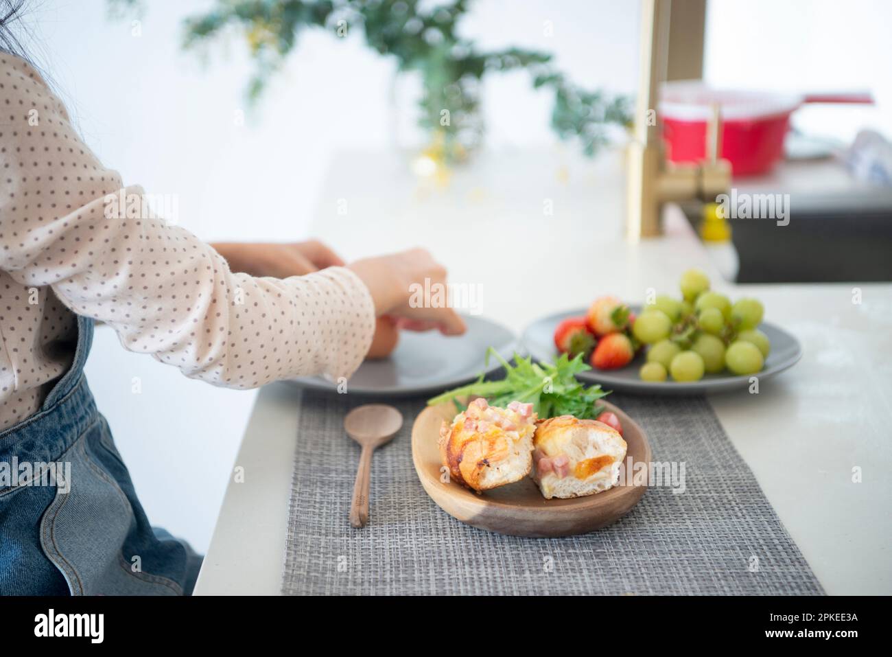 Une fille prenant le petit déjeuner à la table à manger Banque D'Images