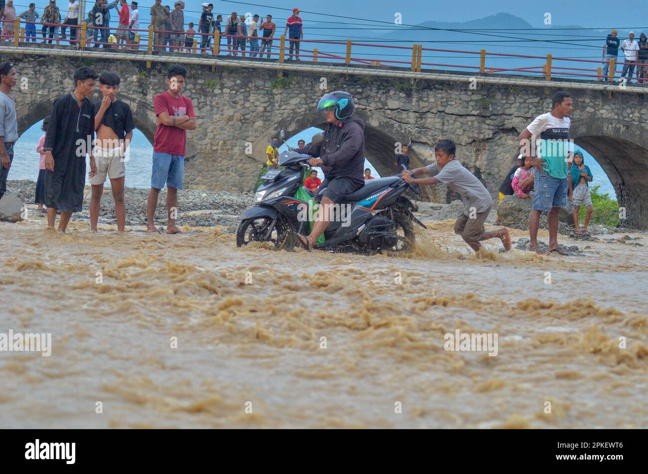 Palu, Indonésie. 07th avril 2023. Un des ponts d'accès reliant les provinces de Sulawesi central et Sulawesi ouest a été coupé, pour être précis dans la ville de Palu, Sulawesi central. Le passage de véhicules à deux et à quatre roues doit utiliser une autre solution en traversant la rivière. Les policiers de la République d'Indonésie ont immédiatement installé une ligne de police sur le pont afin qu'aucun véhicule ne passe et qu'ils n'interdisaient pas aux résidents de passer sur le pont. (Photo de Wahono/Pacific Press) Credit: Pacific Press Media production Corp./Alay Live News Banque D'Images