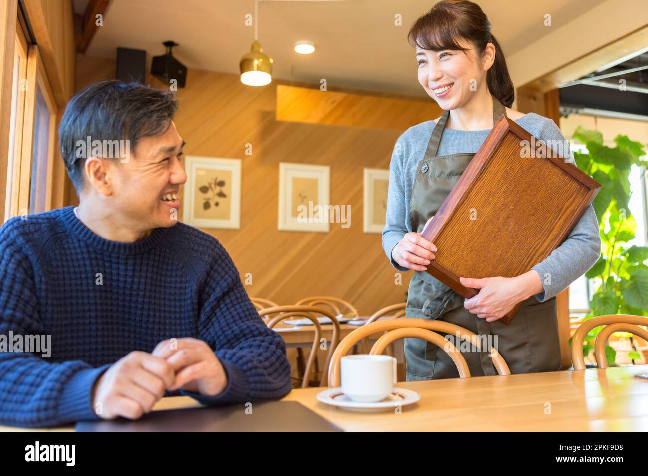 Serveuse servant du café à un client masculin Banque D'Images
