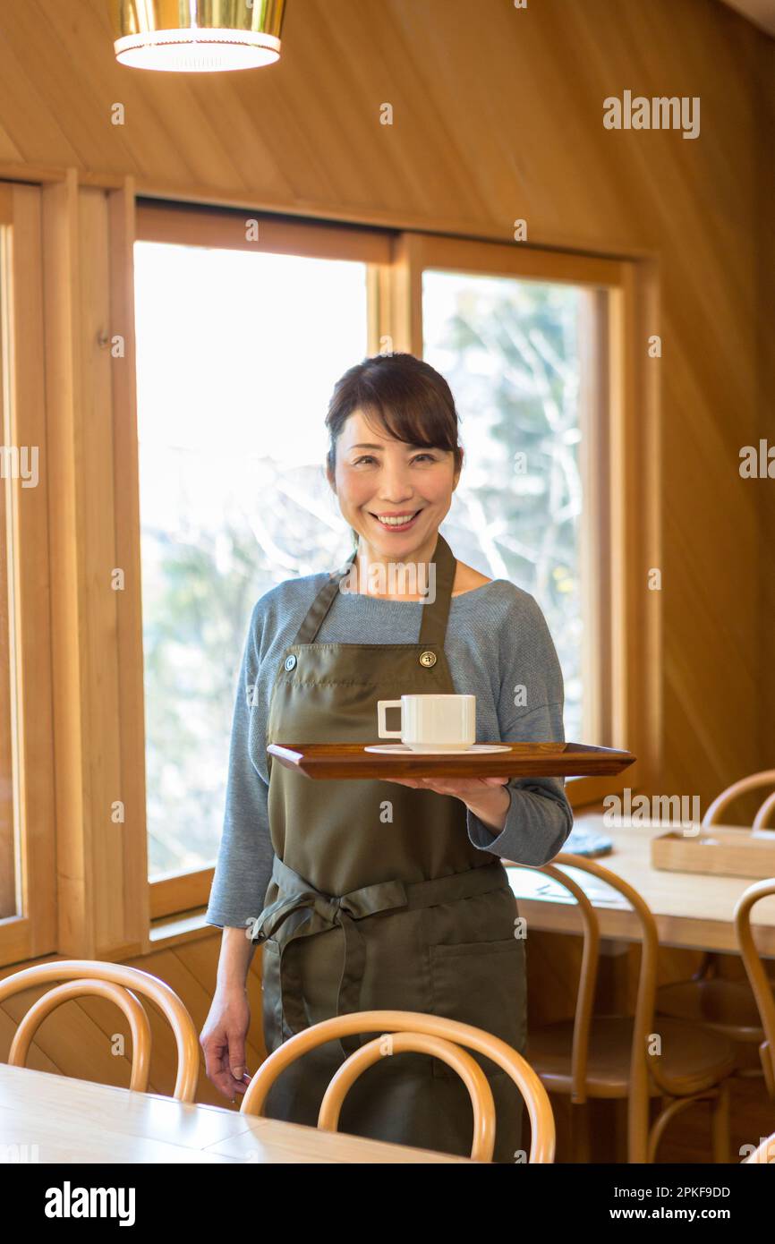 Serveuse féminine debout avec un plateau de café Banque D'Images