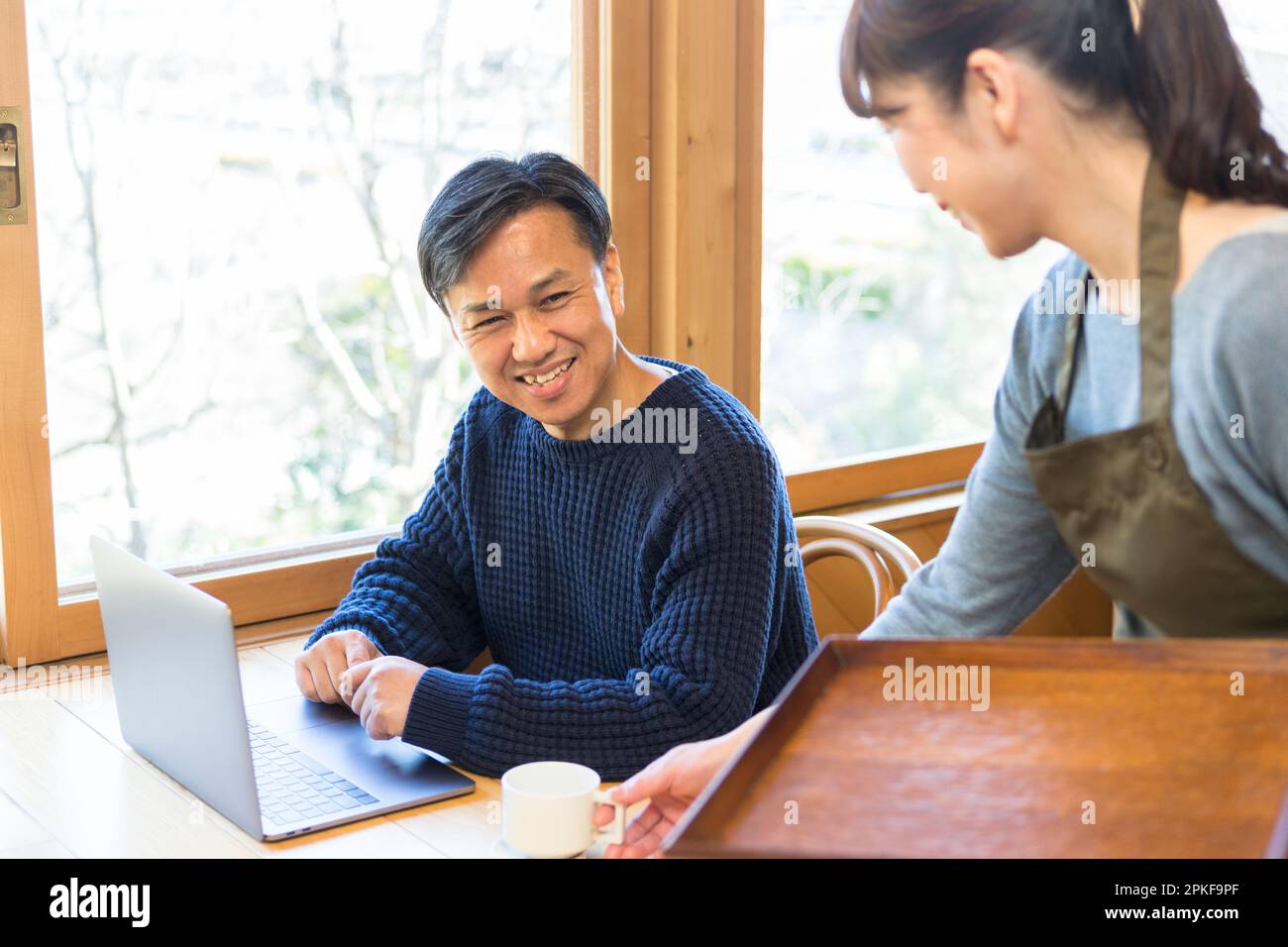 Serveuse servant du café à un client masculin Banque D'Images