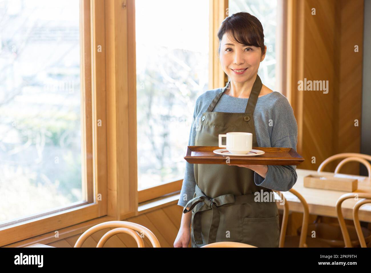 Une serveuse tient un plateau avec du café Banque D'Images