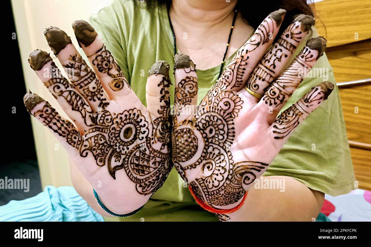 Une belle œuvre d'art dessinée sur la main d'une mariée indienne avec de la tisane heena en condition humide. Banque D'Images