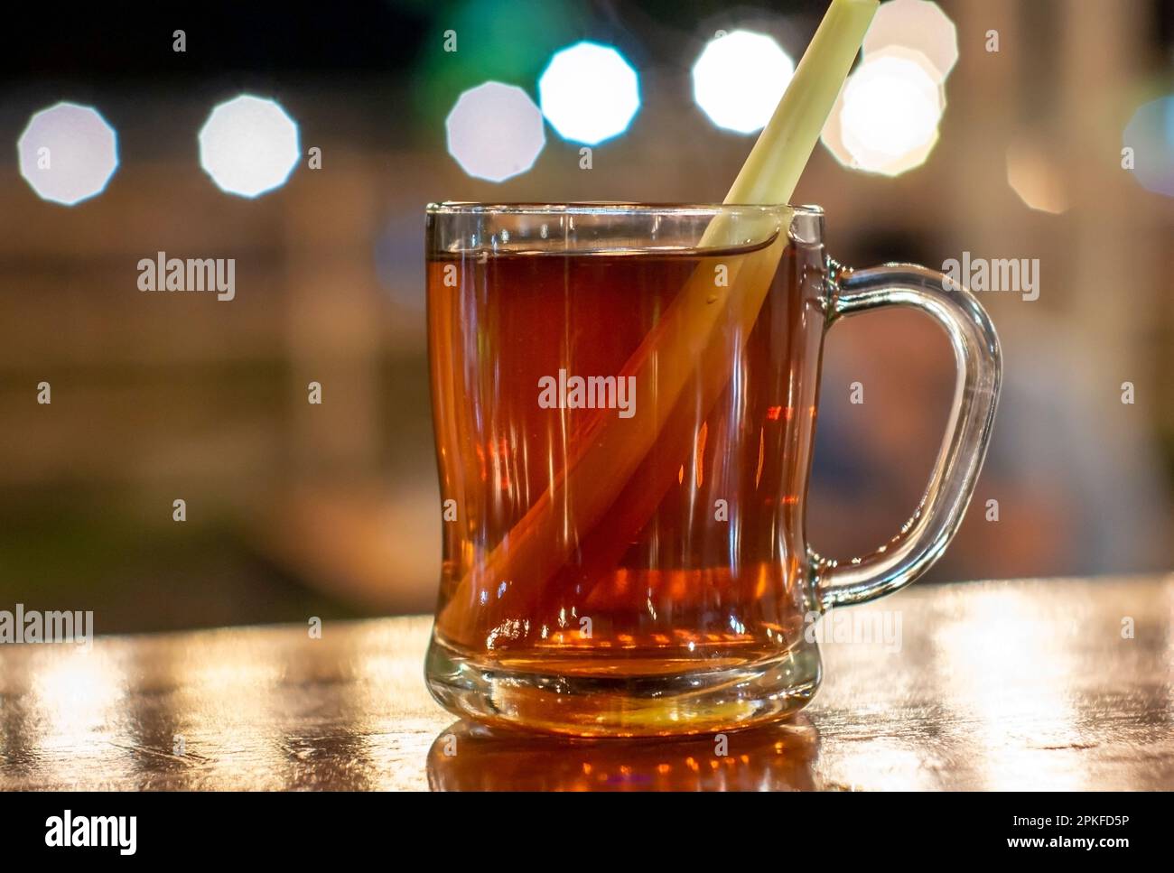 Thé chaud avec citronnelle sur fond de verre et de bokeh Banque D'Images