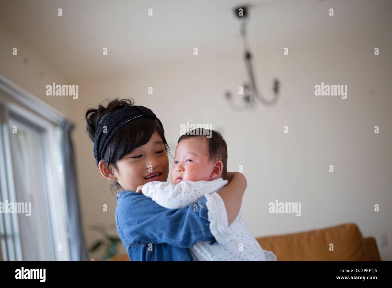 Une fille de l'école élémentaire tenant son petit frère Banque D'Images