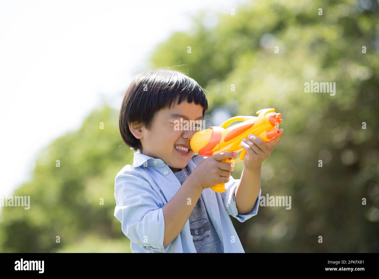 Garçon prenant le but avec le pistolet à eau Banque D'Images Garçon prenant le but avec le pistolet à eau Banque D'Images