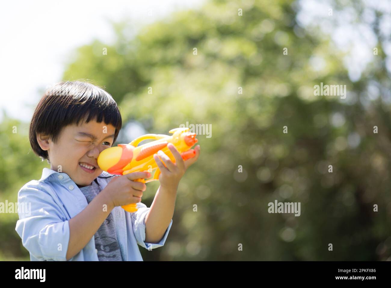 Garçon prenant le but avec le pistolet à eau Banque D'Images Garçon prenant le but avec le pistolet à eau Banque D'Images