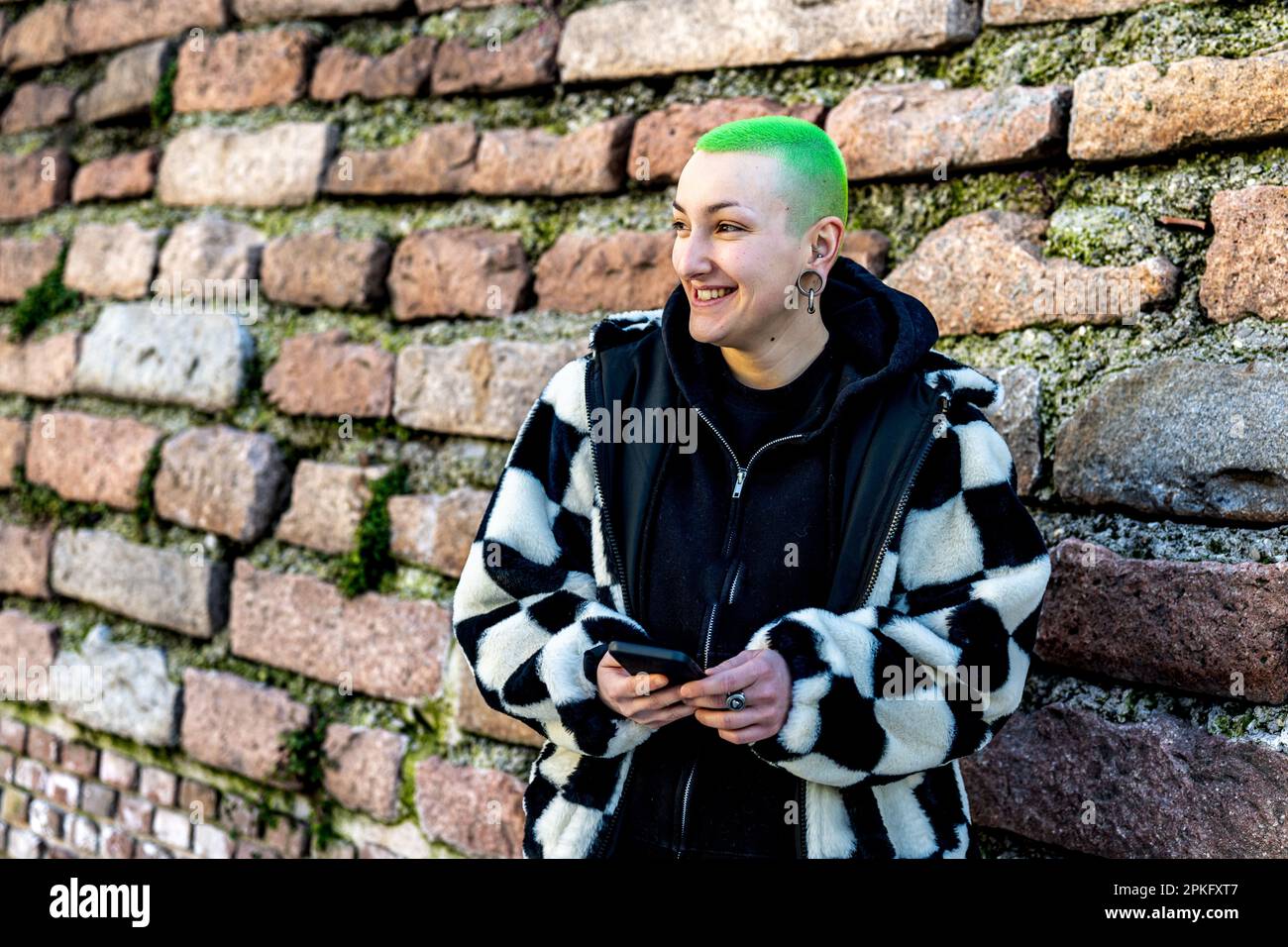 Jeune femme androgyne souriant avec des cheveux de couleur verte Banque D'Images