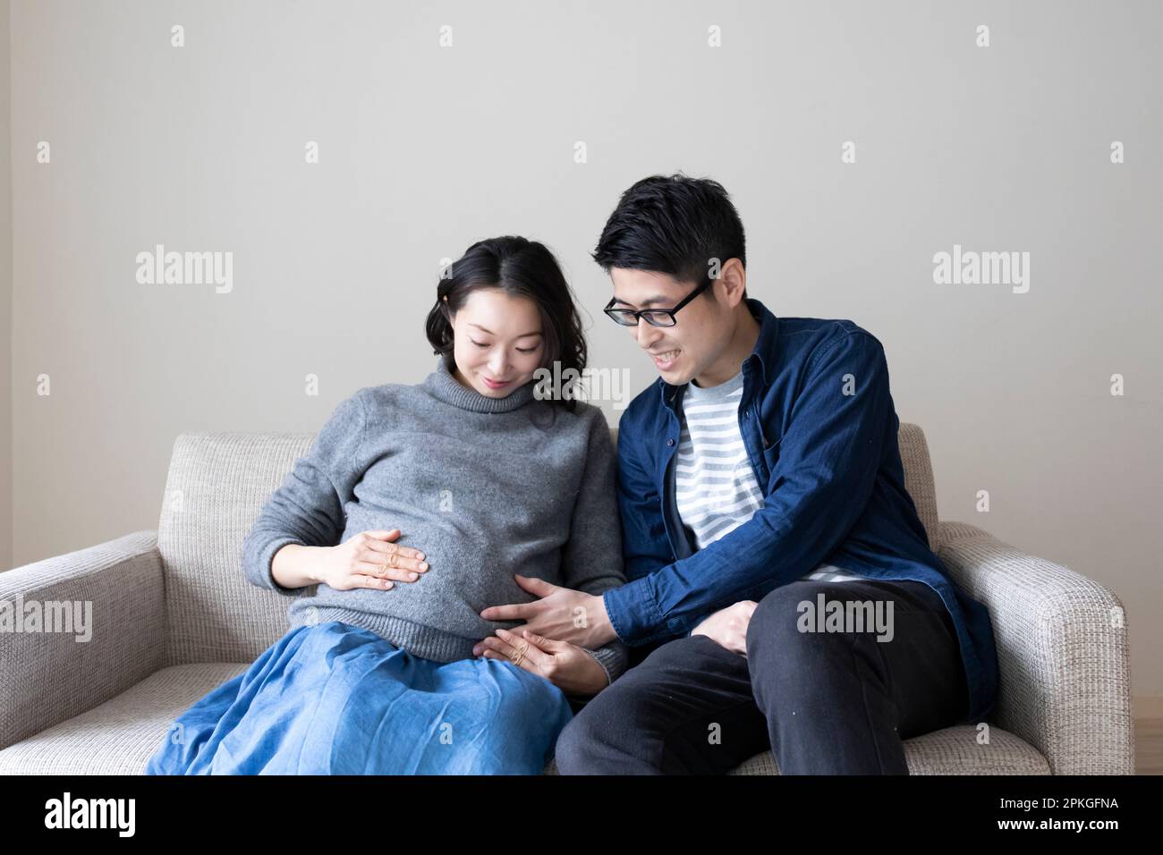 Mari plaçant sa main sur le ventre de sa femme enceinte Banque D'Images
