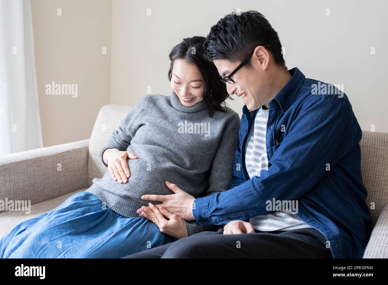 Mari plaçant sa main sur le ventre de sa femme enceinte Banque D'Images