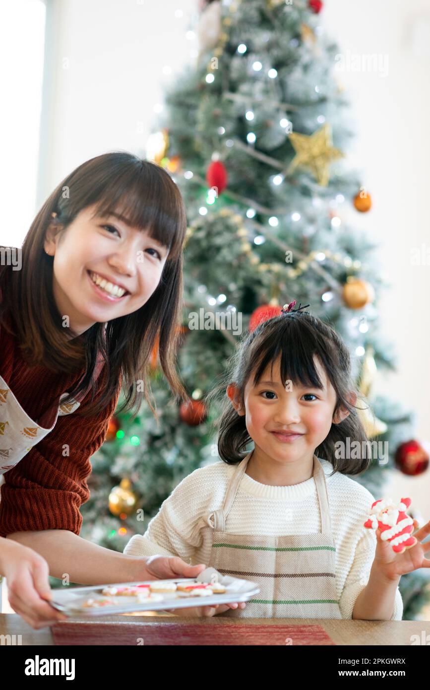 Parents et enfants souriant avec des biscuits glaçants Banque D'Images