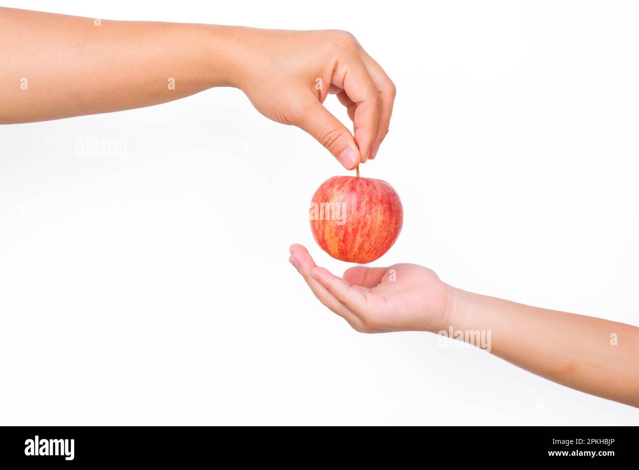 Main tenant morsure pomme rouge isolée sur fond blanc. Pomme rouge mûre dans la main humaine. Banque D'Images