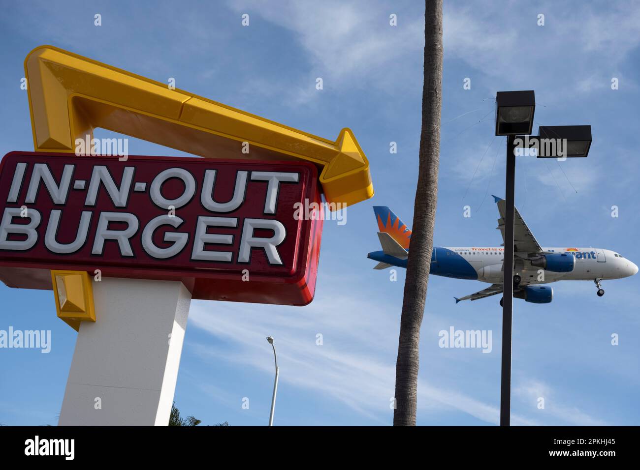 Los Angeles, Californie, États-Unis. 7th avril 2023. Un avion Allegiant Air  Airbus A319 en approche finale à LAX passe devant un hamburger In-N-Out.  Allegiant Air est une compagnie aérienne low-cost dont le