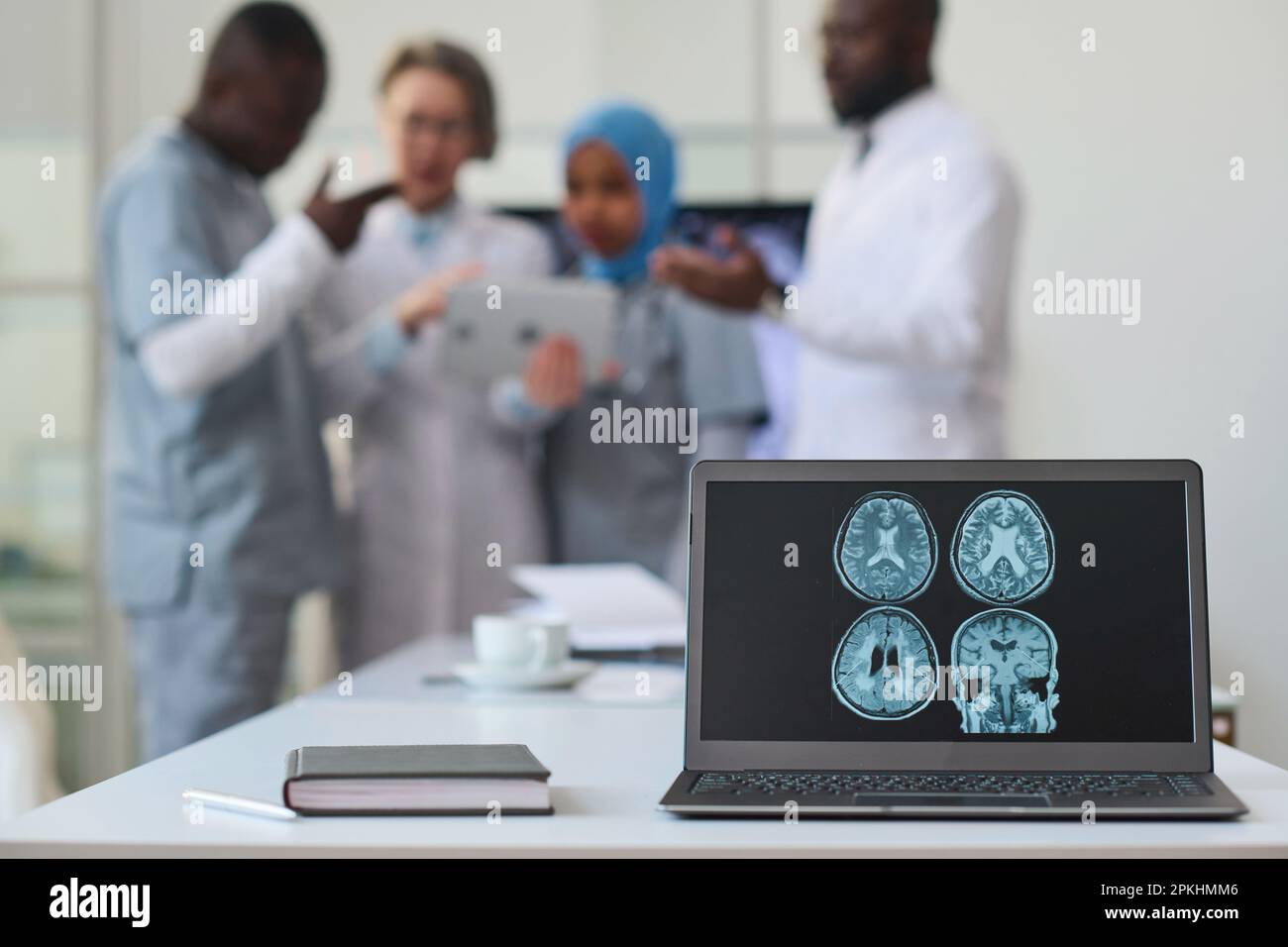 Gros plan de l'image de tomographie cérébrale sur le moniteur de l'ordinateur portable avec des médecins travaillant en équipe en arrière-plan Banque D'Images