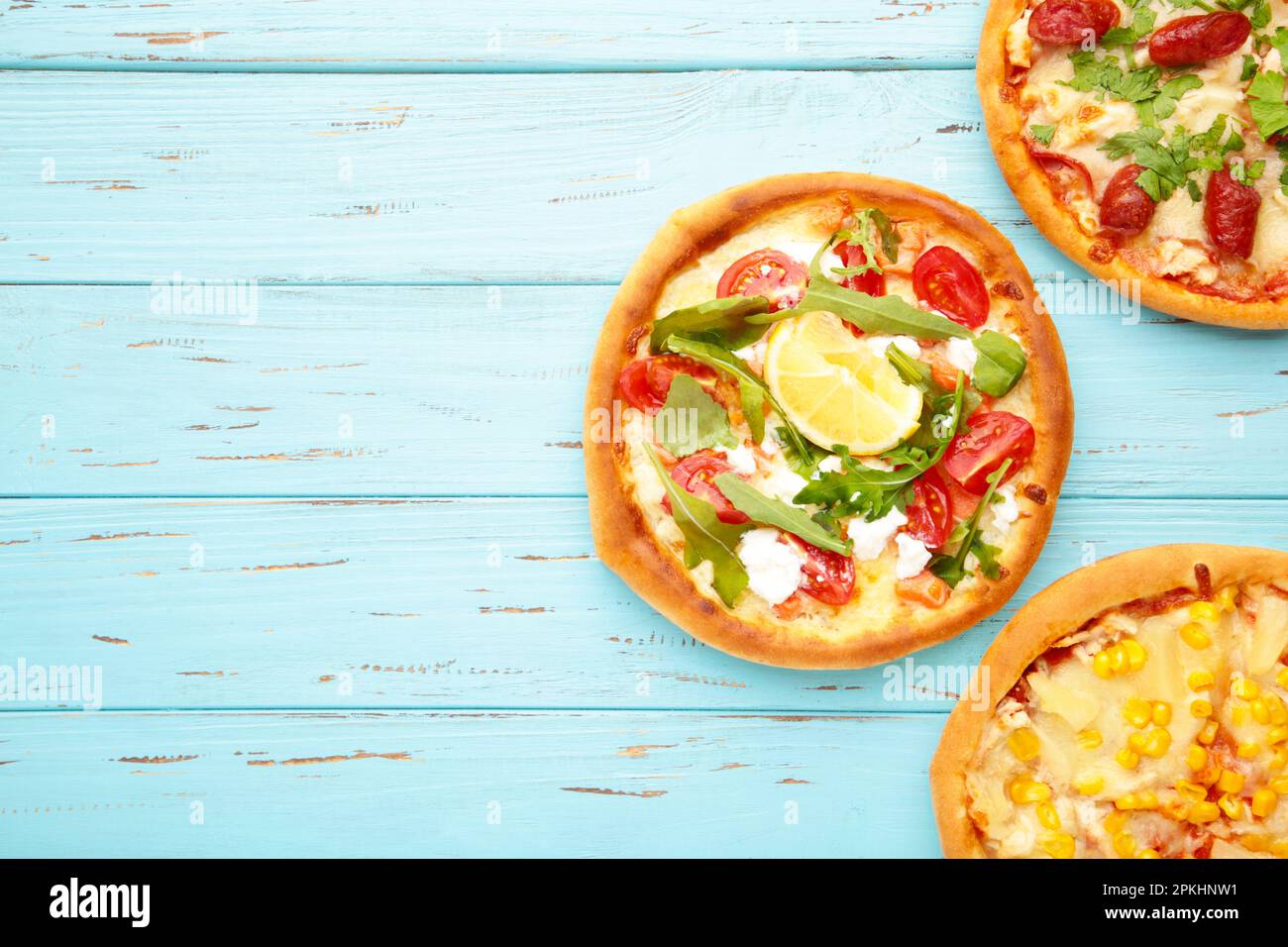 Trois différentes sortes de pizzas sur table en bois bleu avec espace de copie. Vue de dessus Banque D'Images