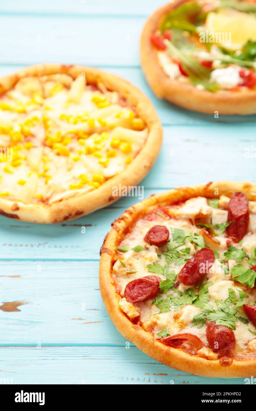 Trois différentes sortes de pizzas sur une table en bois bleu. Aller à la verticale. Vue de dessus Banque D'Images