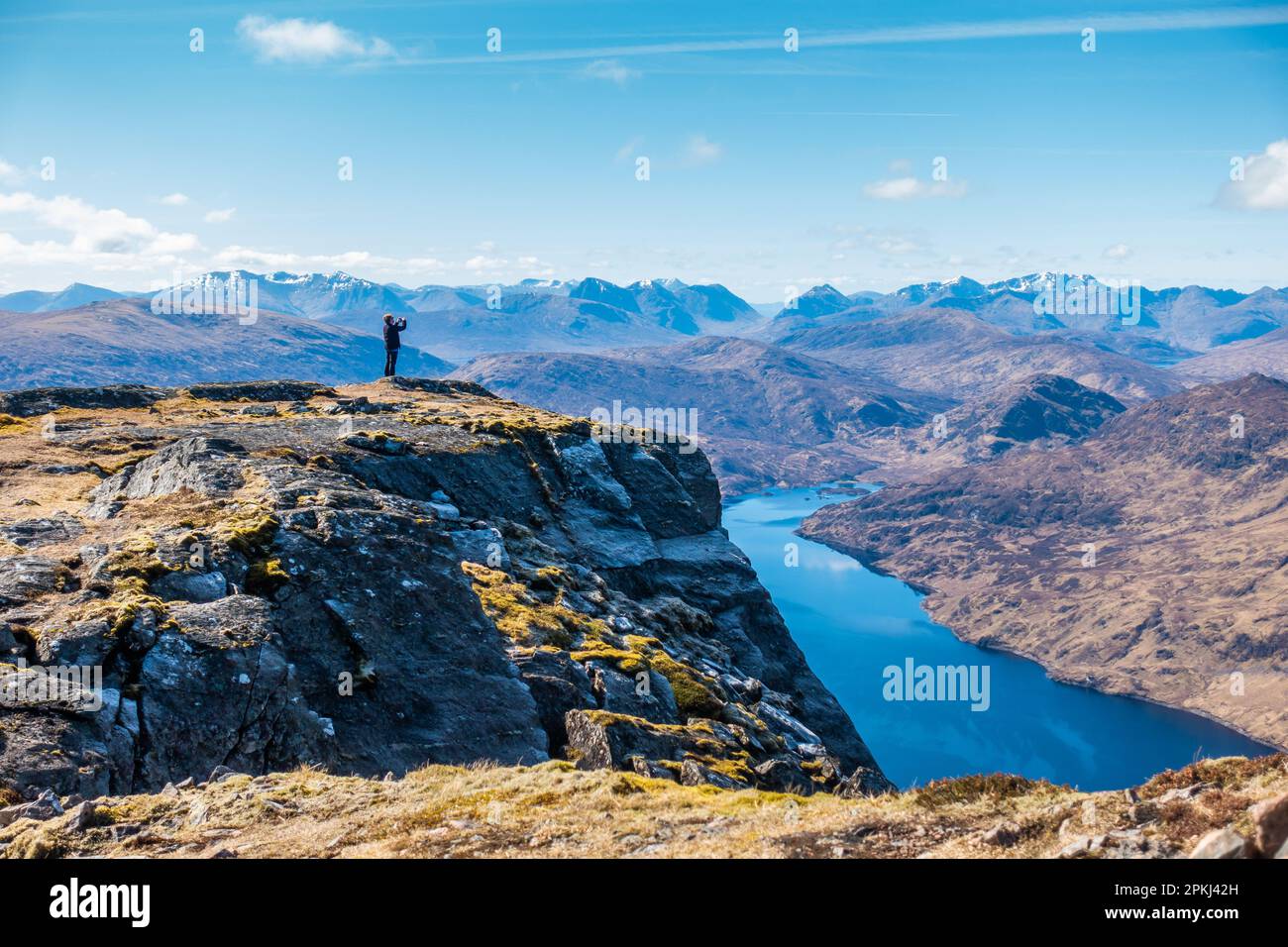 Un marcheur prend une photo près du sommet de la montagne Scottish Munro de Stob Coire Sgriodain près du pont Spean, en Écosse, avec le Loch Treig en dessous Banque D'Images