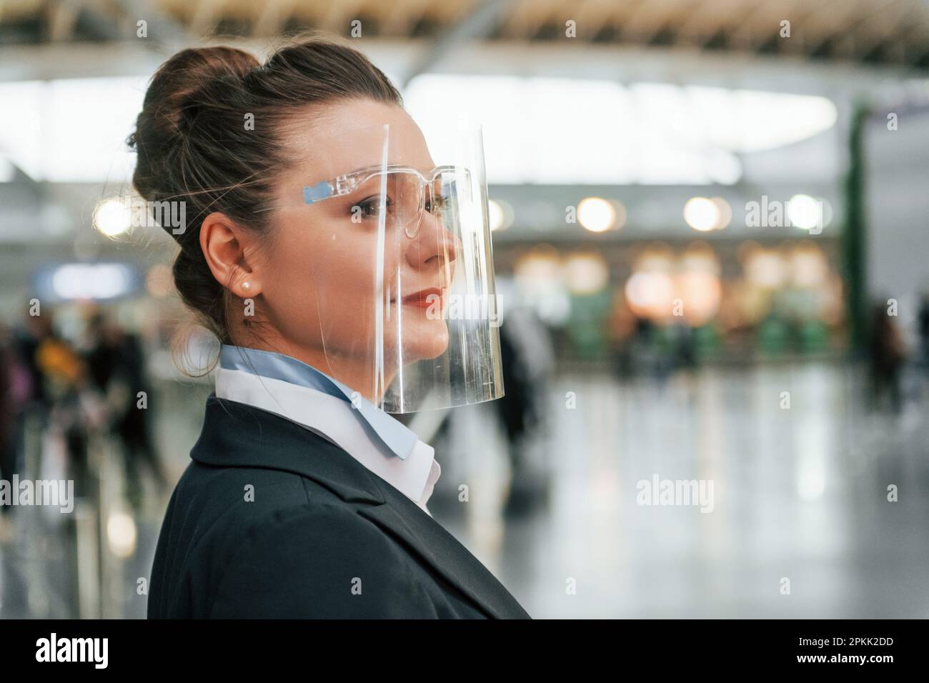 Vue latérale. Une femme travaillant dans des vêtements habillés est debout à l'intérieur Banque D'Images