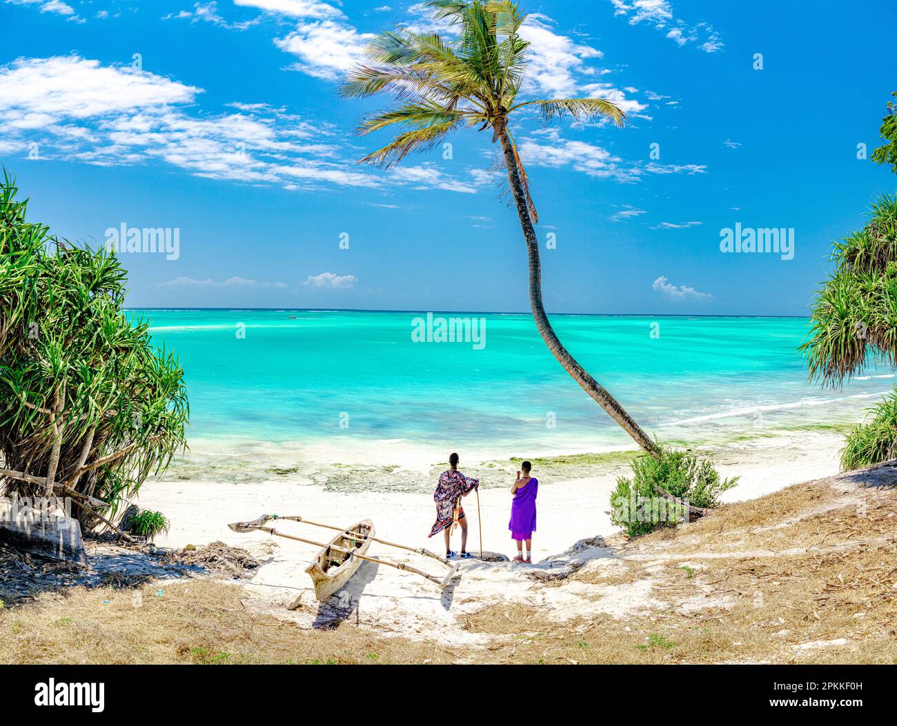 Homme et femme de la tribu Maasai admirant le lagon turquoise sous un palmier, Zanzibar, Tanzanie, Afrique de l'est, Afrique Banque D'Images