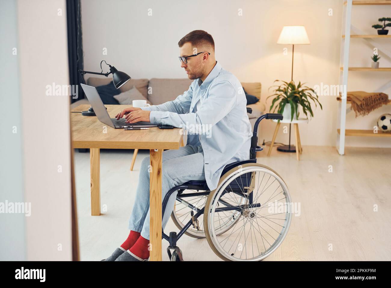 Travailleur indépendant intelligent. Un homme handicapé en fauteuil roulant  est à la maison Photo Stock - Alamy