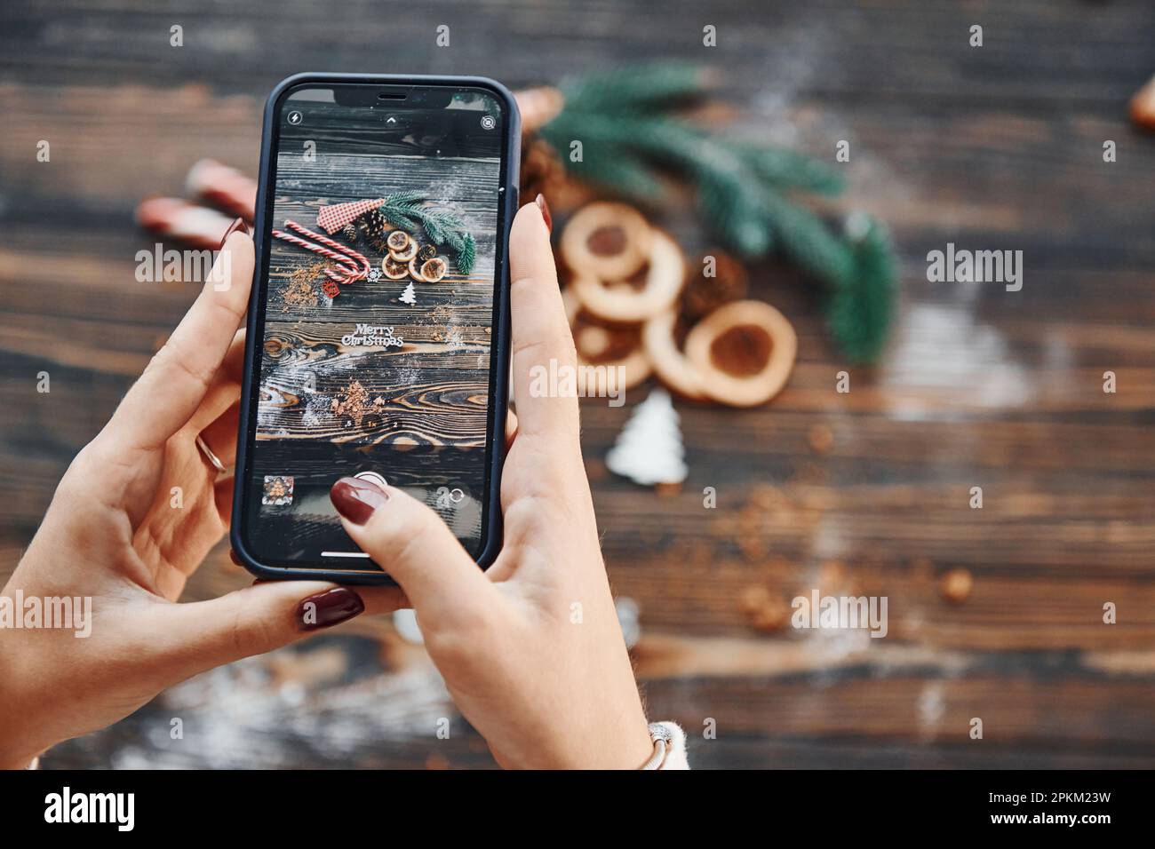 Femme tenant le téléphone. Arrière-plan de Noël avec décoration de vacances. Banque D'Images