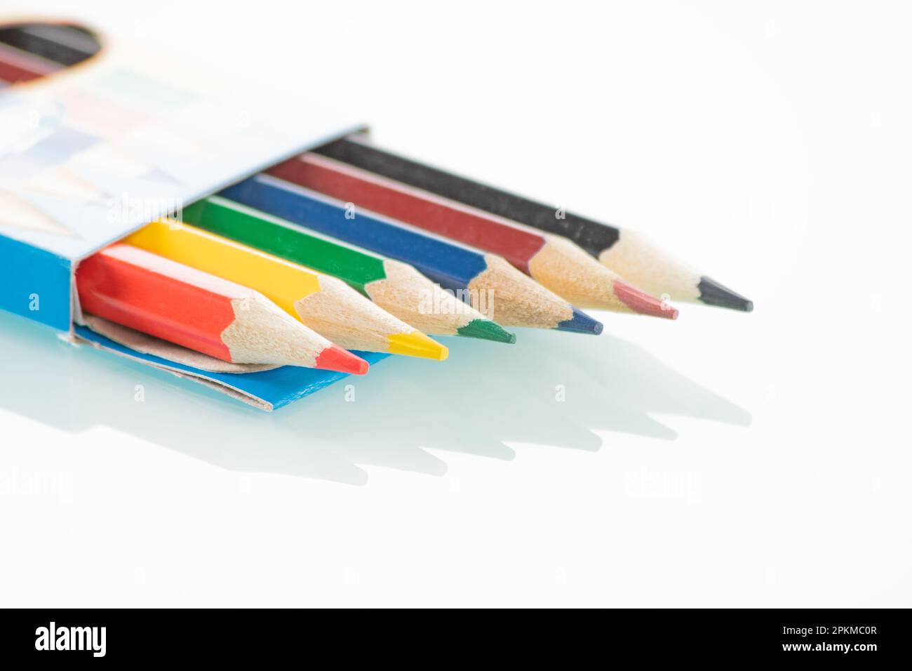 Thème Office. Les crayons de couleur dans une boîte ouverte se trouvent sur  un fond miroir blanc Photo Stock - Alamy