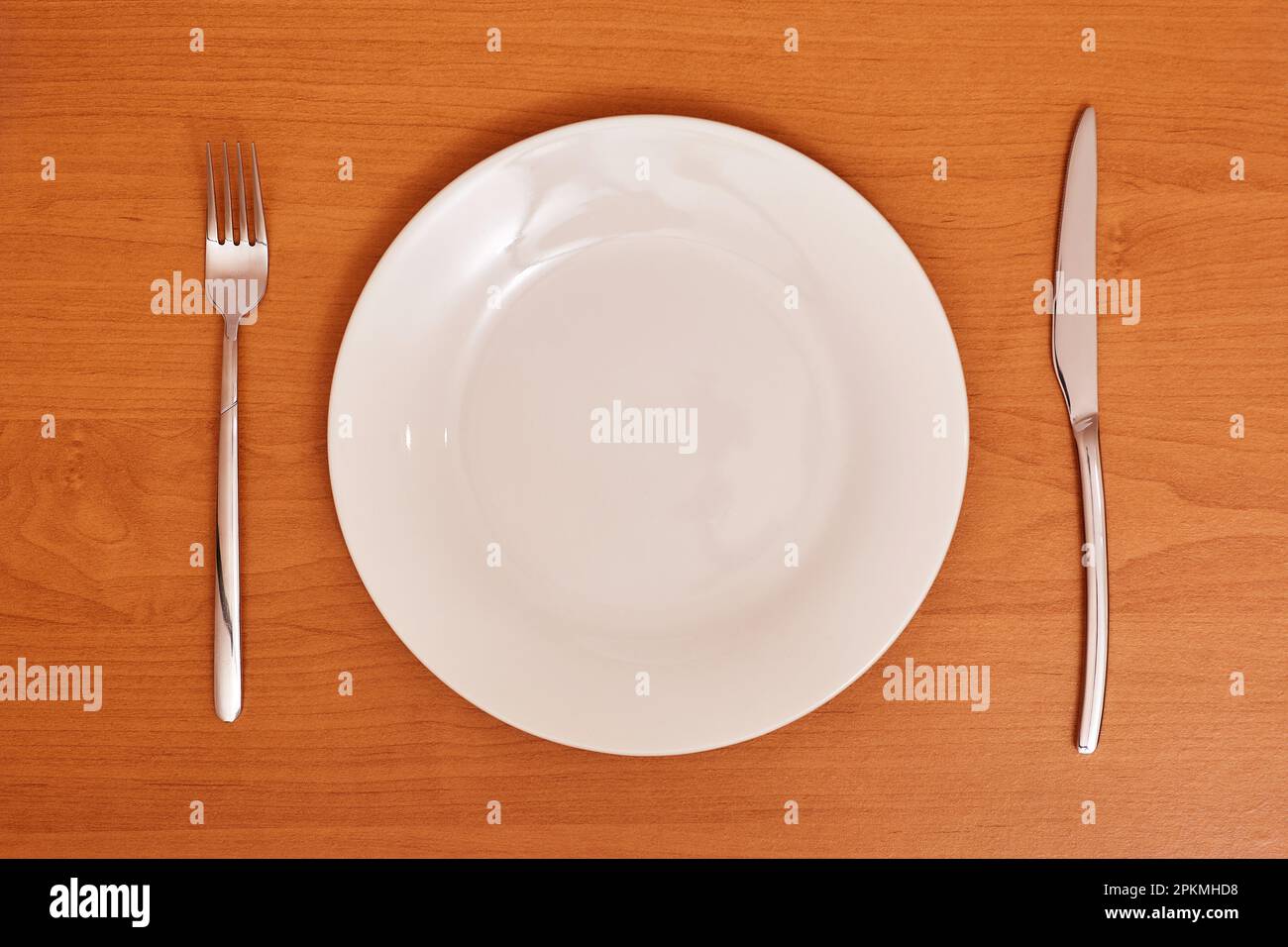 Vider et nettoyer la plaque bleue avec une fourchette et un couteau sur une table en bois comme exemple d'étiquette de table Banque D'Images