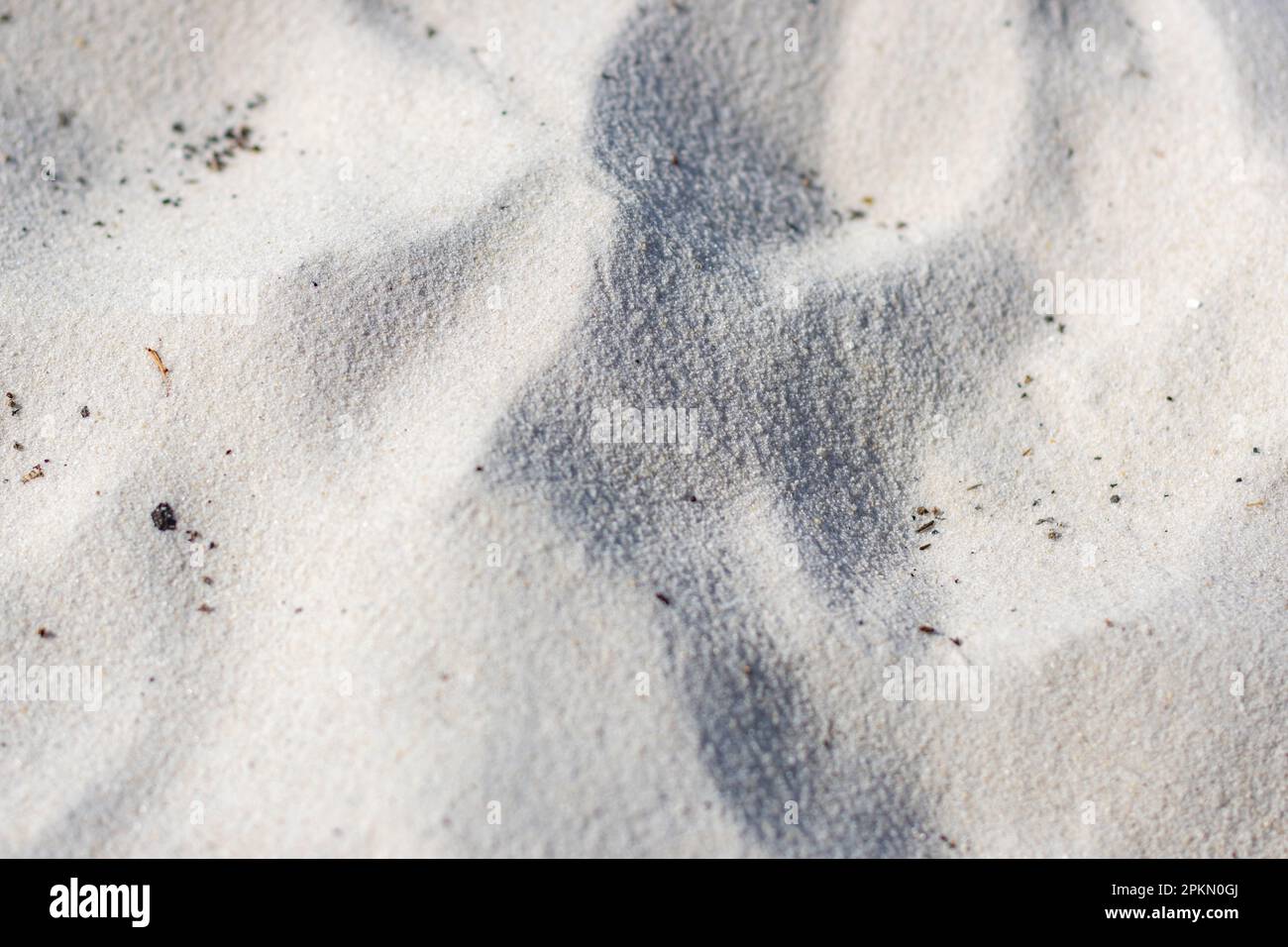 Une image en gros plan du haut du sable blanc fin contaminé par de petites particules noires Banque D'Images