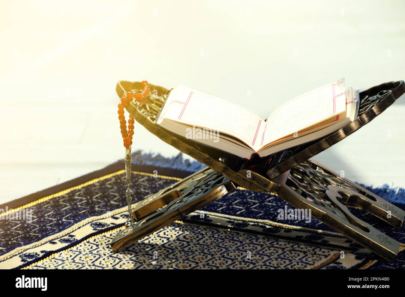 Rehal avec Quran ouvert et Misbaha sur tapis de prière musulman à l'intérieur Banque D'Images