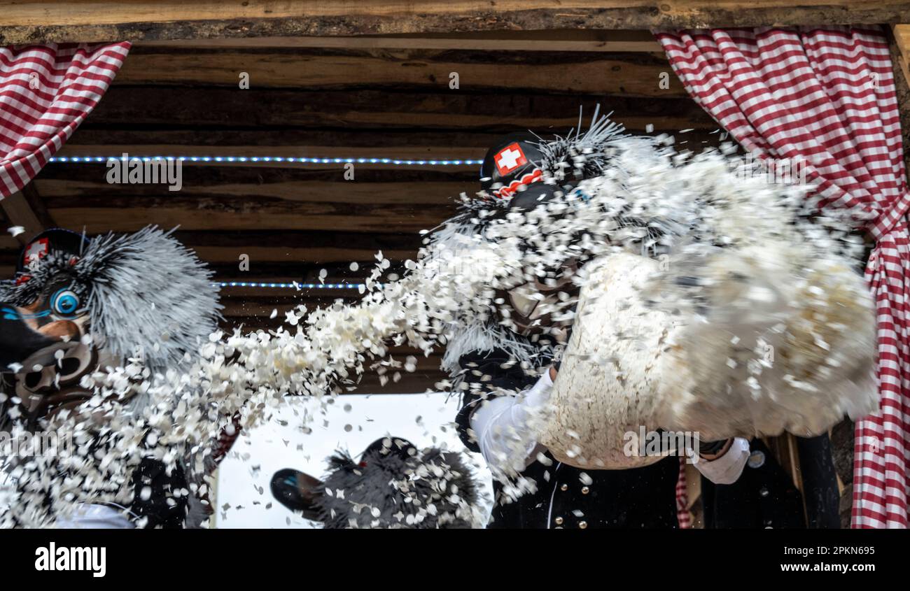 Costume de Waggis à l'intérieur d'un char de parade jetant des confetti au carnaval de Basel Fasnacht en Suisse Banque D'Images