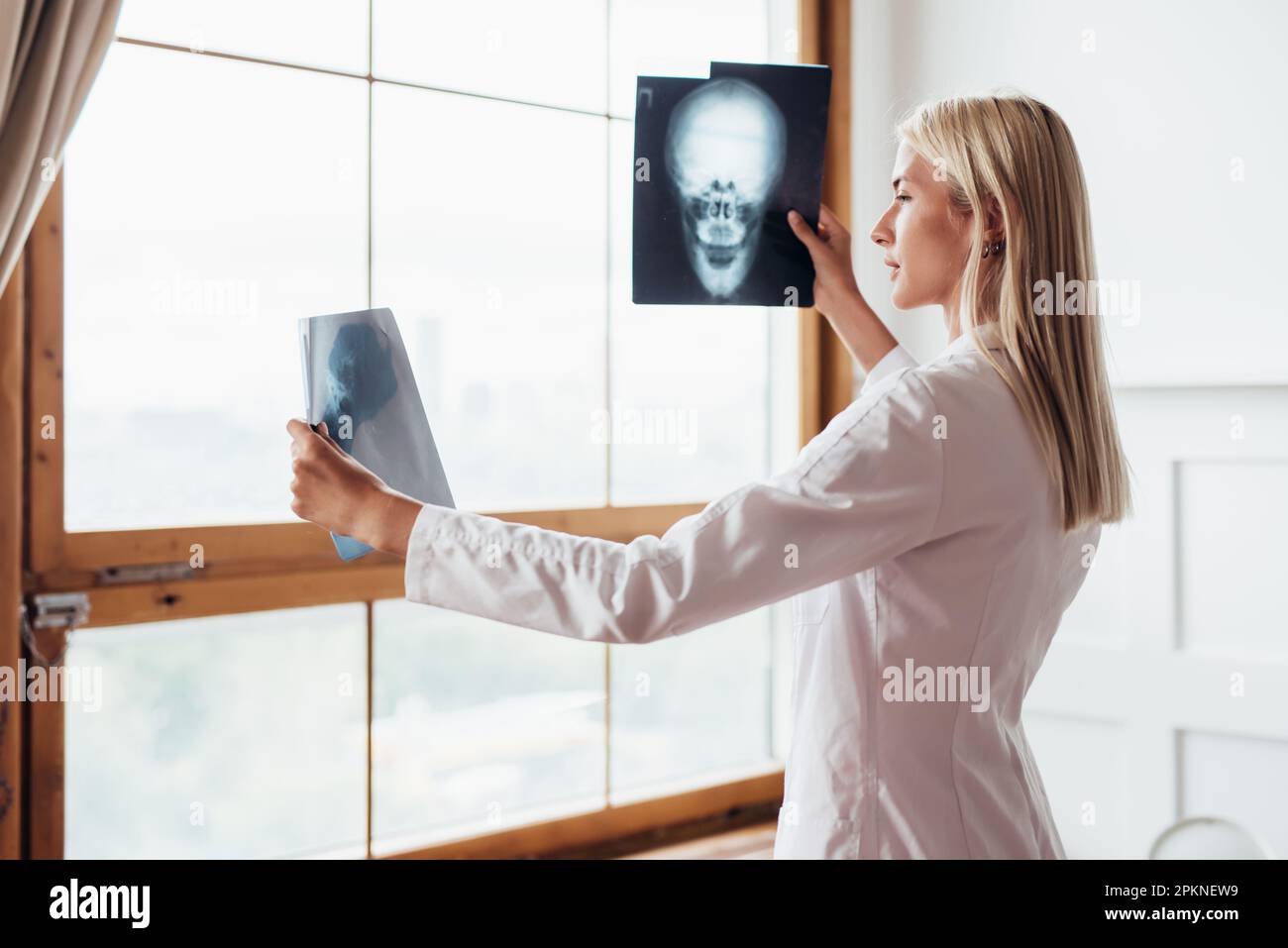 Femme radiologue regardant les acquisitions du crâne Banque D'Images
