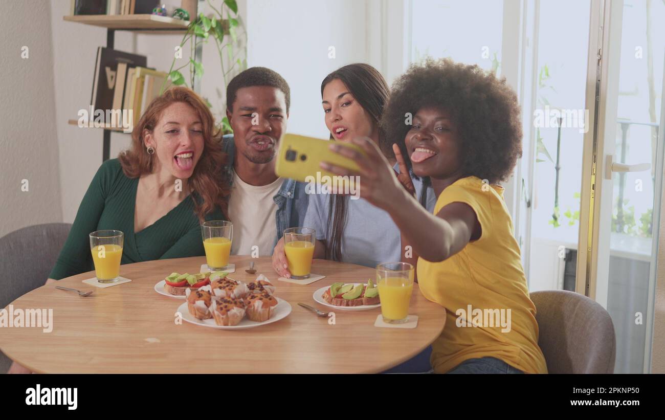 Amis multiethniques s'amuser tout en prenant un selfie pendant le petit déjeuner Banque D'Images
