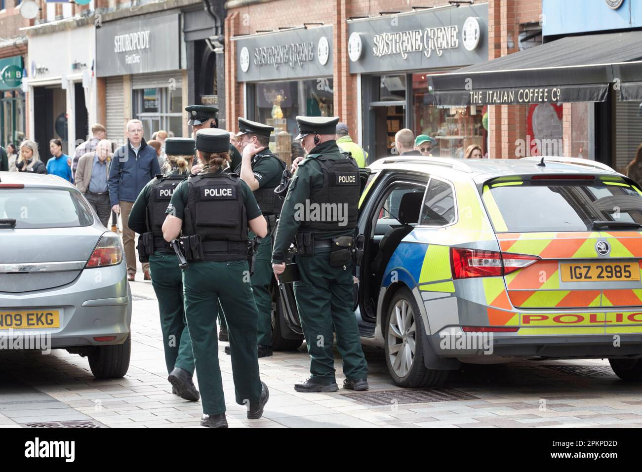 Service de police PSNI d'Irlande du Nord, hommes et femmes, patrouille skoda dans une zone piétonne très fréquentée sur appel en raison de la conduite de la voiture dans un piéton Banque D'Images