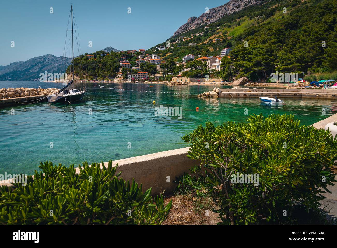 Majestueux petit port avec bateau ancré et bateau à voile, Brela, Dalmatie, Croatie, Europe Banque D'Images