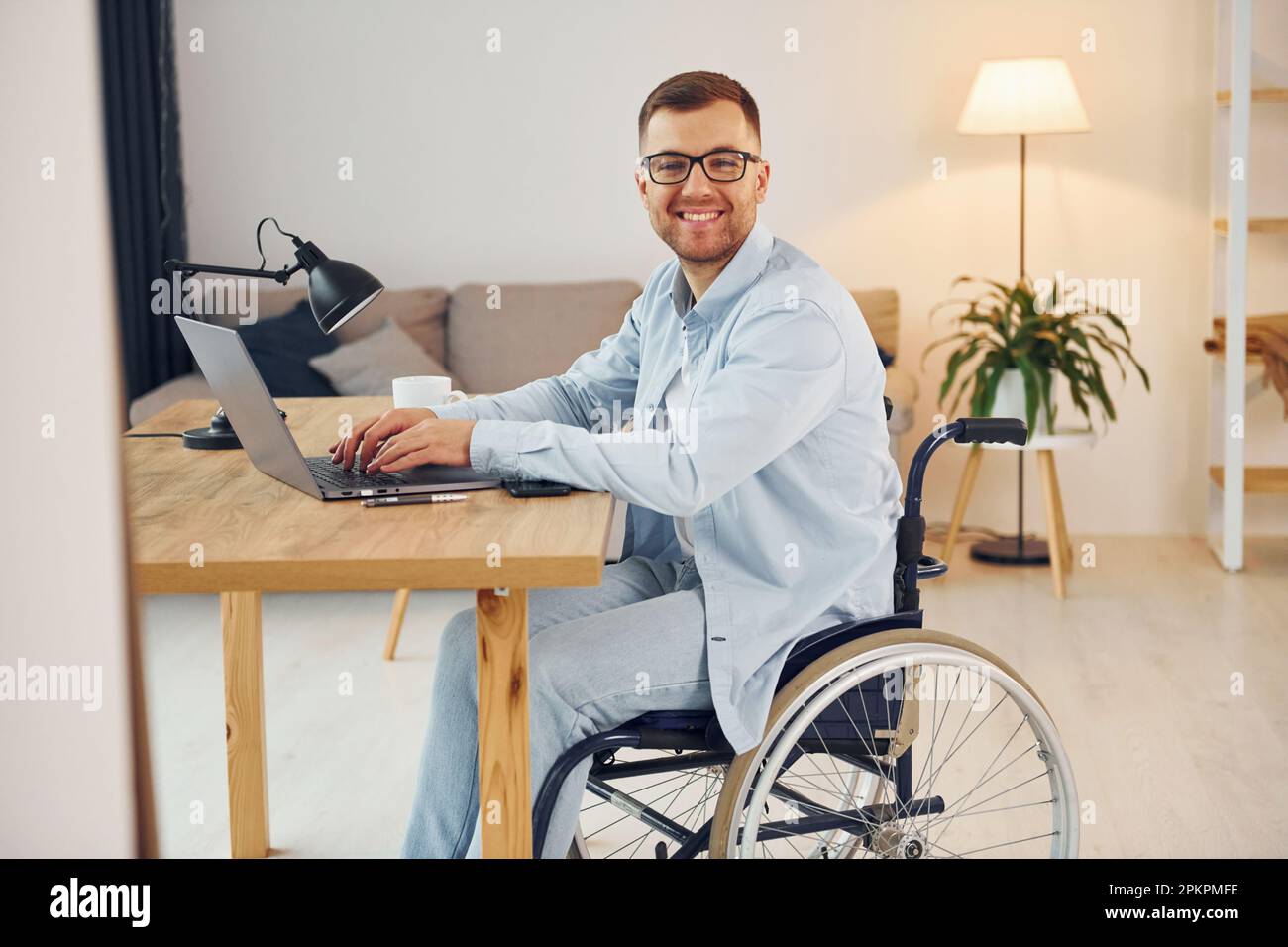 Travailleur indépendant intelligent. Un homme handicapé en fauteuil roulant  est à la maison Photo Stock - Alamy